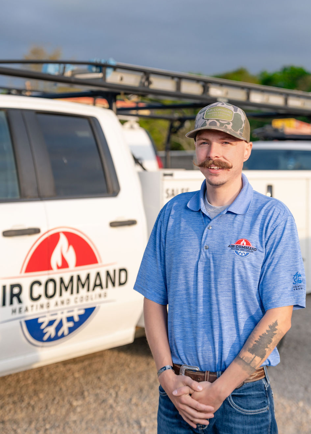 Scott Cokely, Installation Crew Member at Air Command Heating and Cooling, standing in front of company service trucks in Hartford, AL.